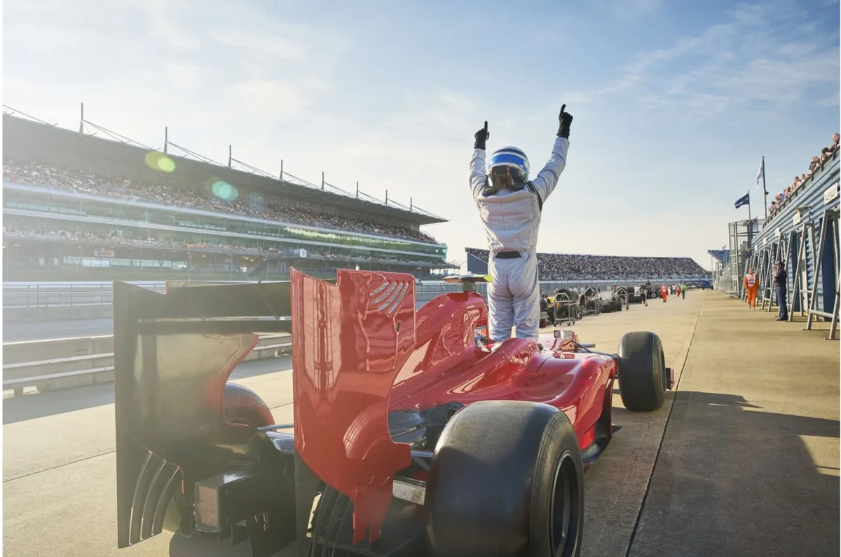 Formula 1 (F1) driver at a Grand Prix, arms raised. 20 drivers compete in 24 Grand Prix tournaments each year for the FIA Formula One World Drivers' Championship Trophy.