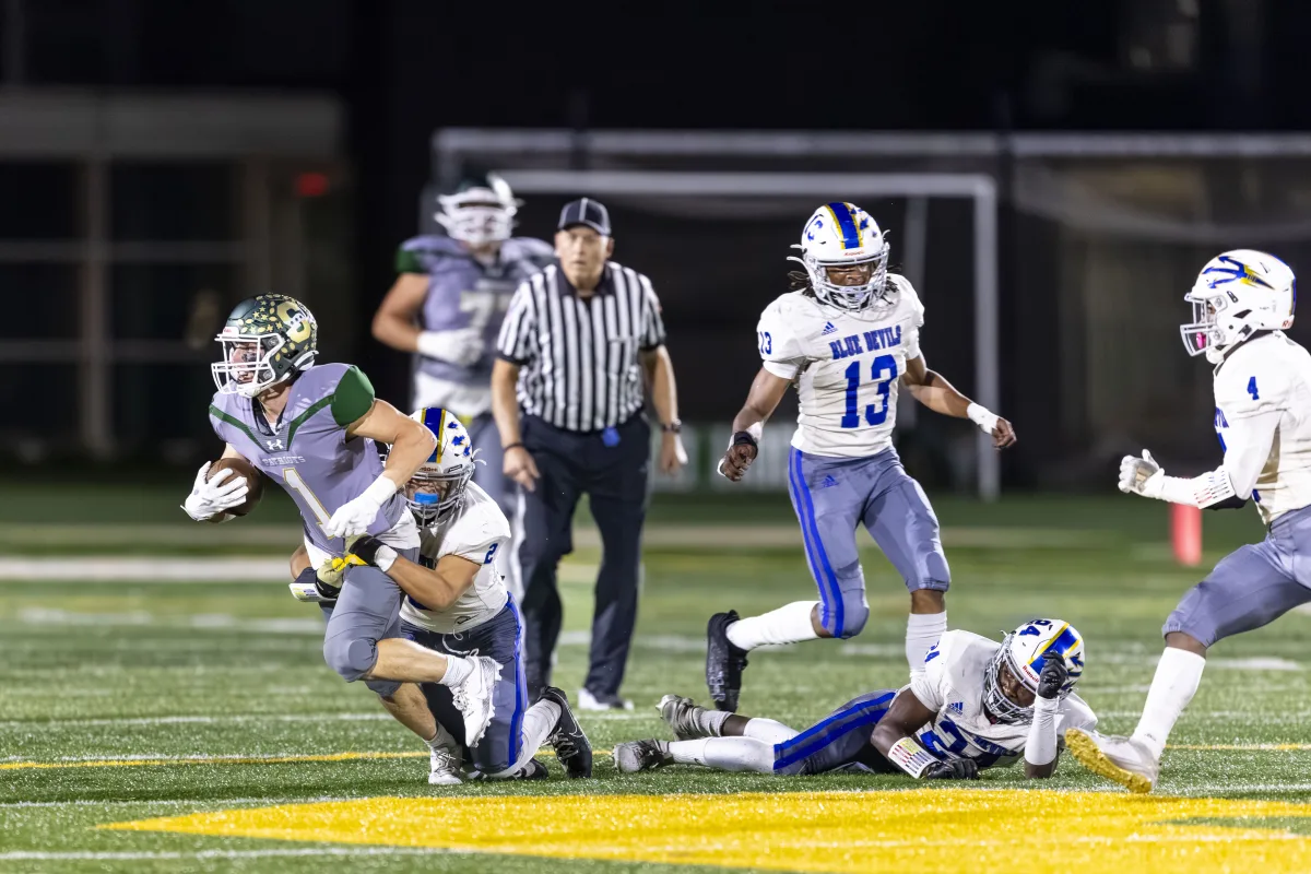 Wide Receiver Zach Hersh '25 runs the ball through the Blue Devils defense. The Patriots made numerous passing plays to hold the Blue Devils off in a crucial game.