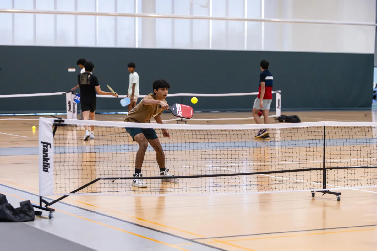 Ruben Lobo ’25 positions himself in front of the net defending an oncoming point from his opponent. Pickleball is a fast paced competitive sport that can be played in groups of two or four.