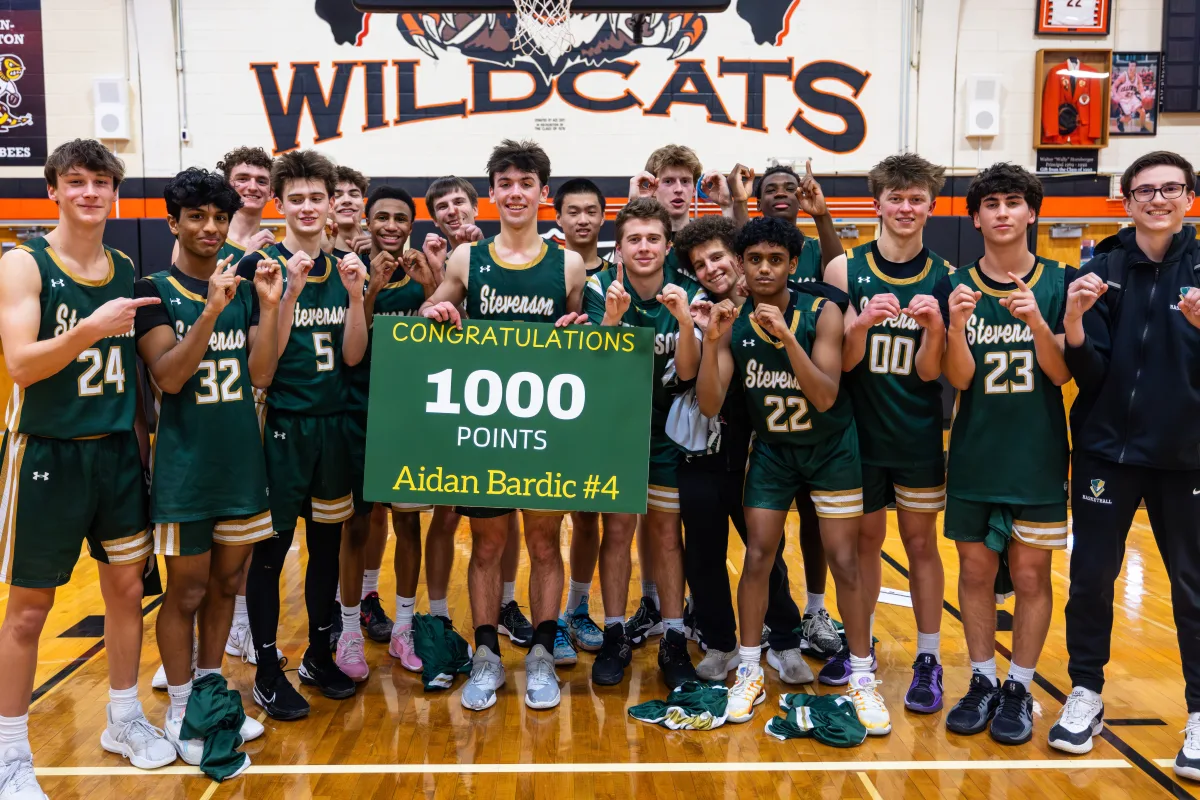 Aidan Bardic '25 stands next to the varsity Boys Basketball team for a picture. Bardic hit the historic 1000-point milestone, only the 7th boys player in Stevenson's history to do so.