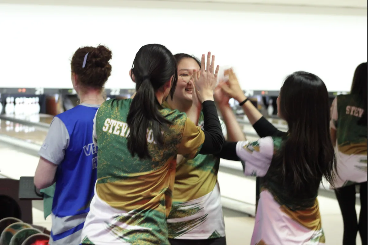 The Girls Stevenson varsity bowling team celebrates with each other following a strike. The team made sure to keep a high morale throughout the match, encouraging each other after every bowl. 
