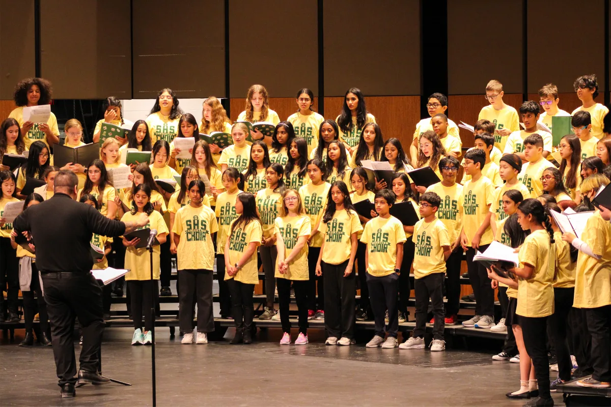 Eighth graders stand on the risers as they rehearse with Choir Director Roland Hatcher. Middle school students have the opportunity to work with the directors and play alongside the highschool band in order to gain an understanding of how their highschool experience will work. 
