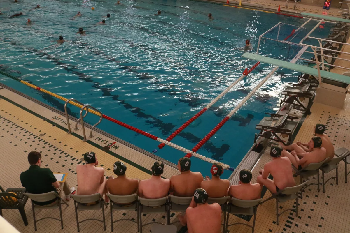 The Patriots bench watches their season opener against the Conant High School Cougars. They prepare for whenever they’re called in to get into the water next.